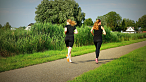 Two women running on a trail.